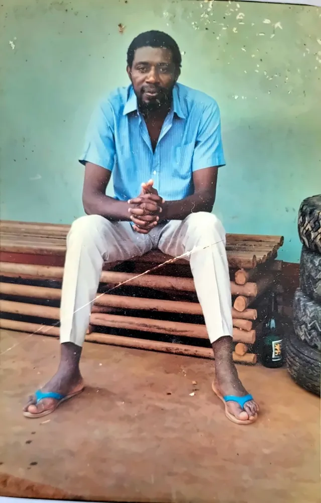 Paul Sanjong assis en chemise bleue